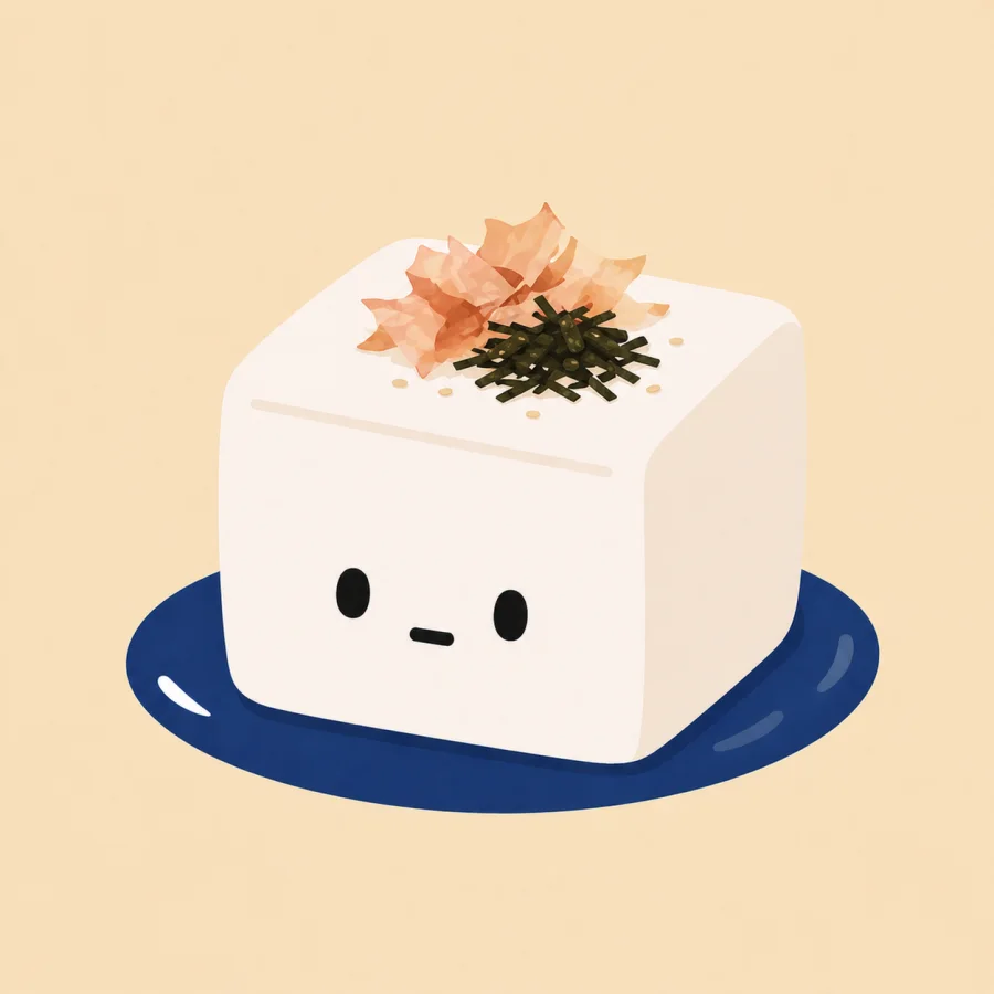 A cute tofu character on a navy plate with bonito flakes and scallions.