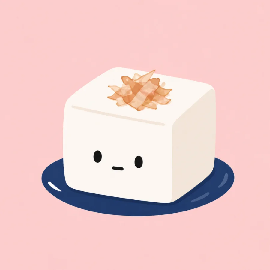 A cute tofu character on a navy plate with bonito flakes on top.