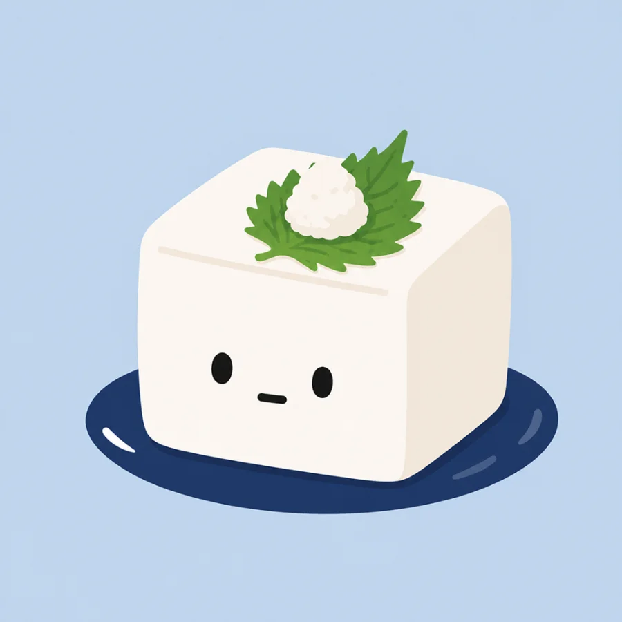 A cute tofu character on a navy plate with shiso and grated daikon.