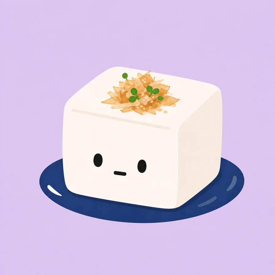 A cute tofu character on a navy plate with myoga and shiso.